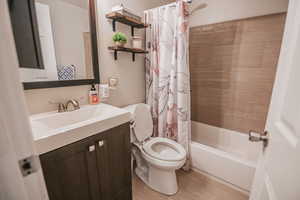 Full bathroom featuring shower / tub combo, vanity, and light wood finished floors