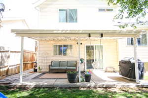 Back of house with a patio and an outdoor living space