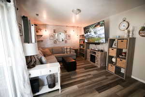 Living room featuring wood walls and dark wood-style floors