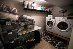 Laundry room with washing machine and dryer, dark wood-style floors, and a textured ceiling