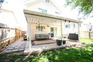 Rear view of property featuring a fenced backyard, a patio, and an outdoor hangout area