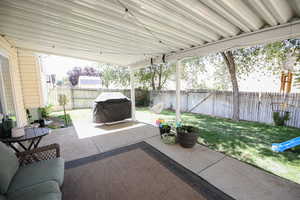 Fenced backyard with a patio area and grilling area