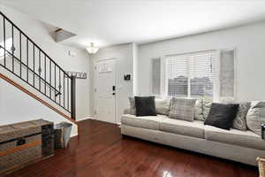 Living room with wood-type flooring and stairway