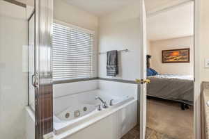 Ensuite bathroom with a tub with jets and a shower stall