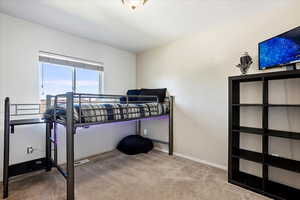 Bedroom with light colored carpet and baseboards