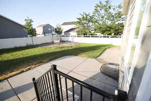 Fenced backyard featuring a patio area, a residential view, and a playground