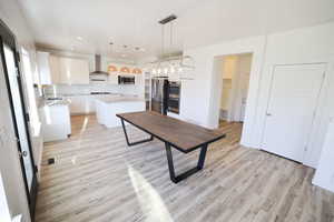 Kitchen featuring backsplash, light wood-style floors, a kitchen island, white cabinetry, and recessed lighting