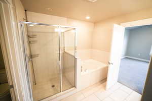 Full bathroom with tile patterned floors, a bath, a stall shower, and recessed lighting