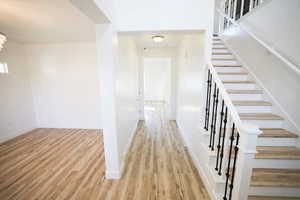 Entryway featuring wood finished floors, stairs, and a chandelier