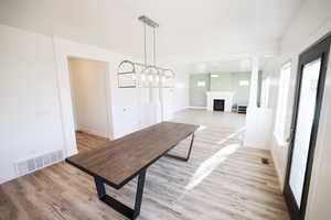 Unfurnished dining area featuring light wood-style floors and a fireplace