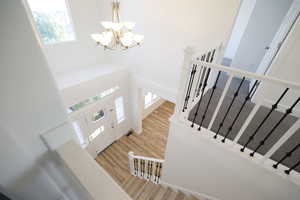 Entrance foyer featuring a towering ceiling, light wood finished floors, and a chandelier