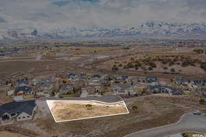 Aerial view of residential area with property parcel outlined and a mountainous background