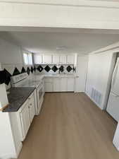 Washroom with light wood-style floors and a sink