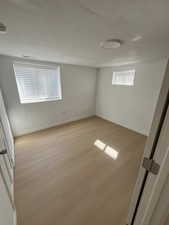 Unfurnished bedroom featuring light wood finished floors and a textured ceiling