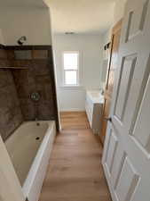 Bathroom featuring light wood-style floors, vanity, and washtub / shower combination