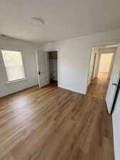 Unfurnished bedroom with light wood finished floors and a closet