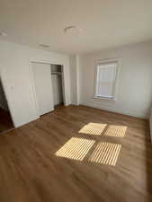 Unfurnished bedroom with a closet and wood finished floors