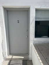 Doorway to property featuring stucco siding