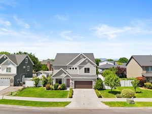 Craftsman house featuring a residential view, an attached garage, driveway, stone siding, and a shingled roof