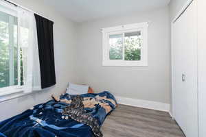 Bedroom with wood finished floors and a closet