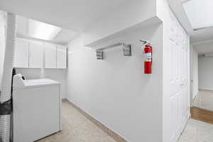 Laundry area featuring cabinet space and independent washer and dryer