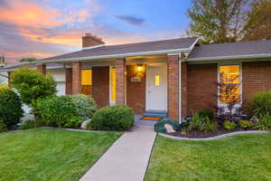 Ranch-style house with roof with shingles, a lawn, and brick siding