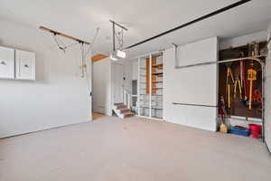 Garage featuring concrete block wall and a garage door opener