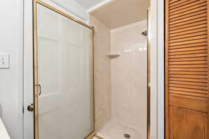 Bathroom featuring a closet and a stall shower