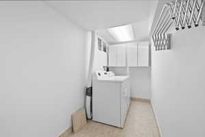 Washroom with cabinet space and washing machine and clothes dryer
