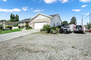 Ranch-style house featuring concrete driveway, brick siding, and a garage