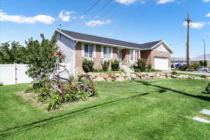 Ranch-style house with brick siding, an attached garage, and a front lawn