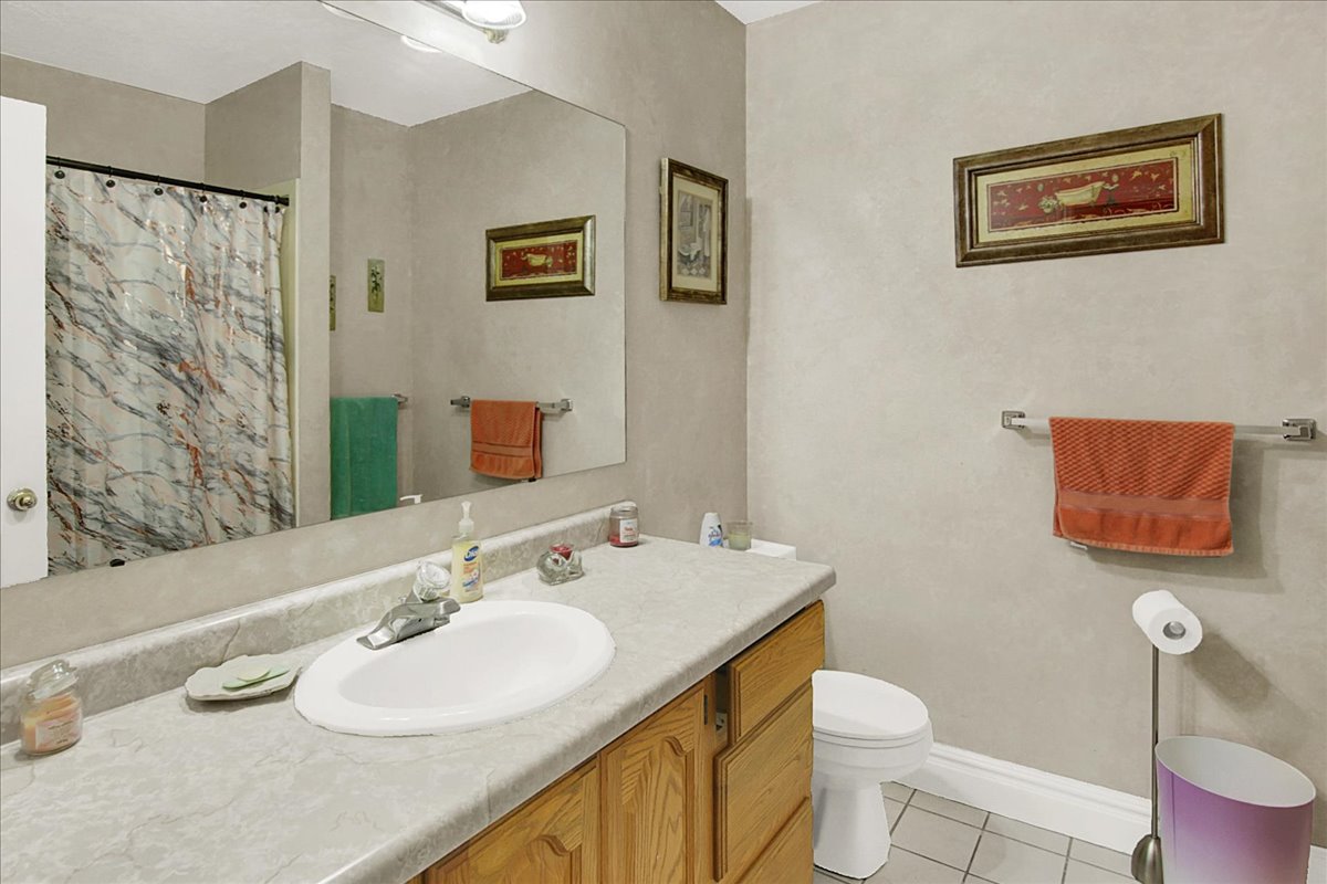 Bathroom with vanity, light tile patterned floors, and a shower with curtain