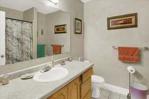 Bathroom with vanity, light tile patterned floors, and a shower with curtain