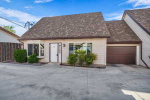 Cape cod home featuring a shingled roof, a garage, and driveway