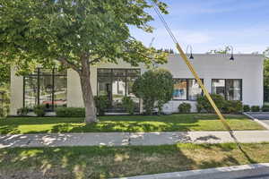View of front of house featuring stucco siding and a front lawn
