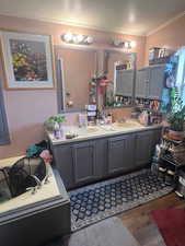 Full bathroom featuring dark wood-style flooring, crown molding, and a textured ceiling