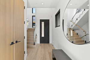 Foyer with stairs, light wood-style floors, and recessed lighting