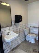 Bathroom with tile walls and a wainscoted wall