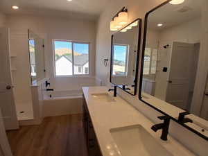 Full bath featuring dark wood-style floors, a bath, a stall shower, and recessed lighting