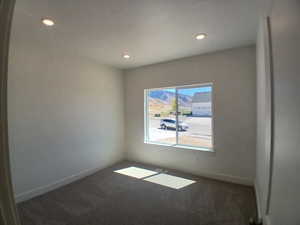 Unfurnished room featuring dark colored carpet and recessed lighting