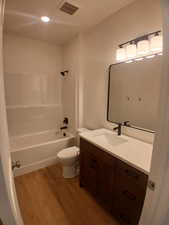 Bathroom featuring vanity, shower / washtub combination, light wood-style flooring, and recessed lighting