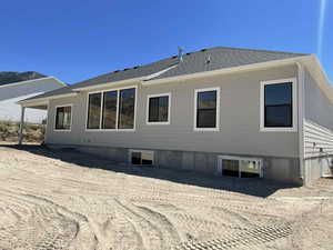 Back of house with a shingled roof