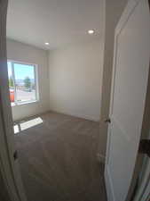 Unfurnished room with dark carpet and recessed lighting