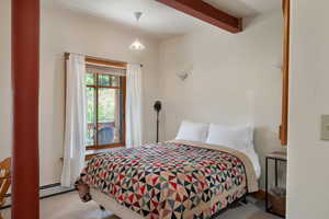 Bedroom featuring carpet, beamed ceiling, in the studio apartment