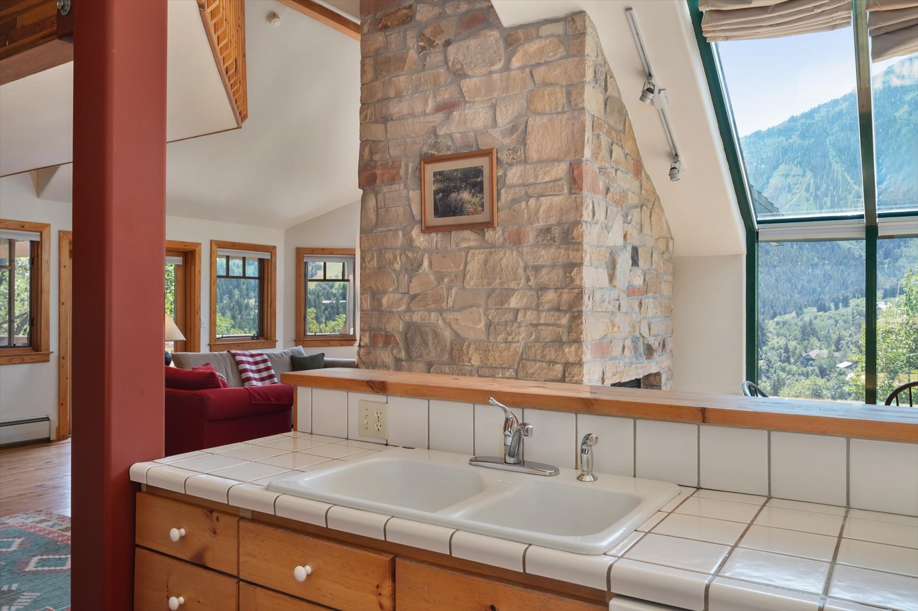 Kitchen with plenty of natural light, tile counters, lofted ceiling, and open floor plan