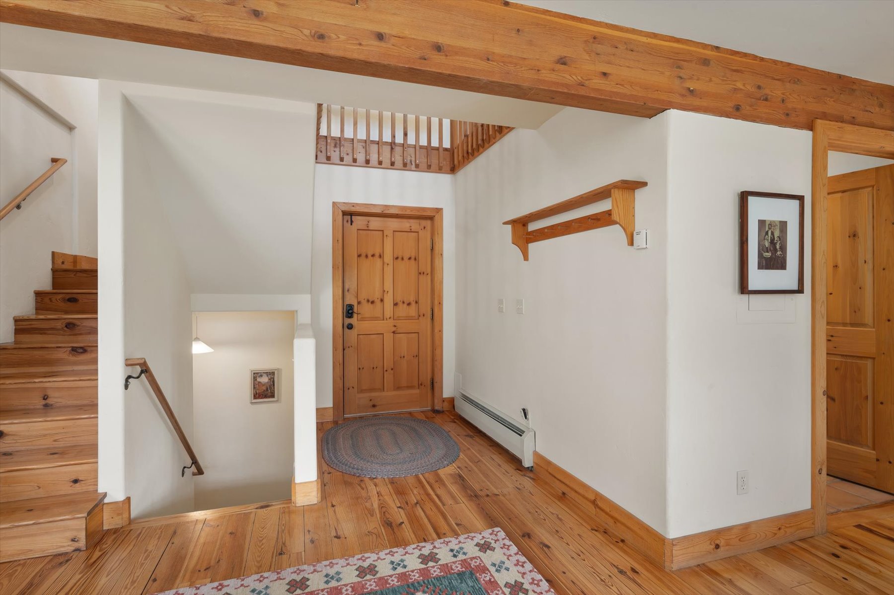 Entryway featuring knotty pine floors and exposed beams