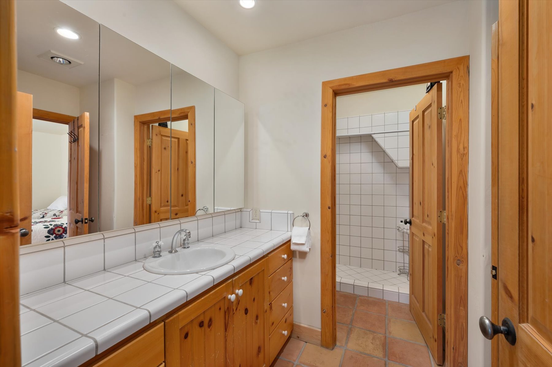 A three quarter bath with Saltillo tiled floors. This bathroom can be accessed by the adjoining bedroom or from the family  room area.