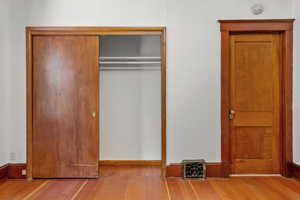 Unfurnished bedroom with hardwood / wood-style flooring and a closet