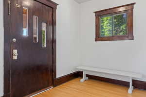 Foyer featuring light wood finished floors and baseboards