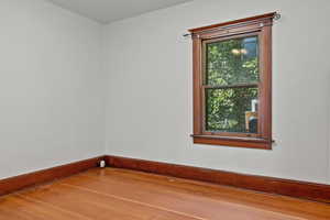 Empty room with wood-type flooring and baseboards